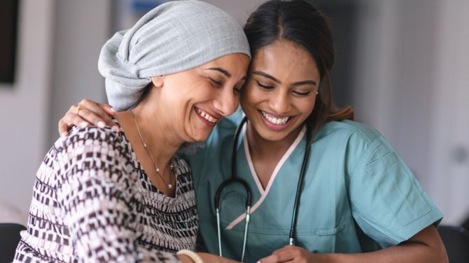 Una enfermera abraza a una paciente con cáncer